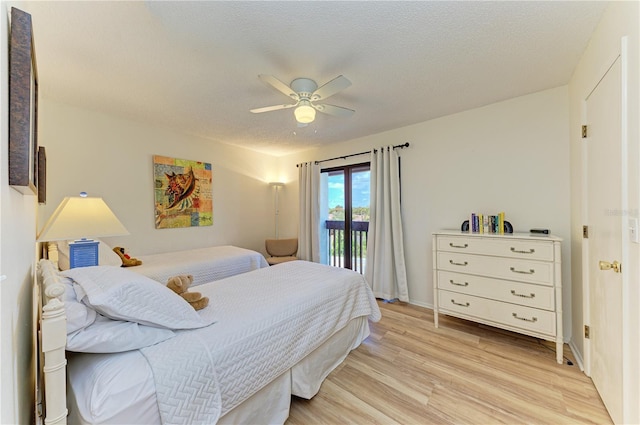 6840 Midnight Pass Rd Unit 6840, Sarasota, FL 34242 - bedroom featuring access to outside, light wood-style floors, a ceiling fan, and a textured ceiling
