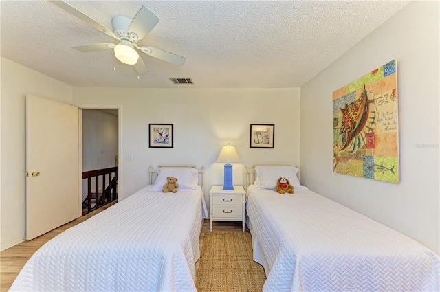 6840 Midnight Pass Rd Unit 6840, Sarasota, FL 34242 - bedroom featuring wood finished floors, ceiling fan, and a textured ceiling