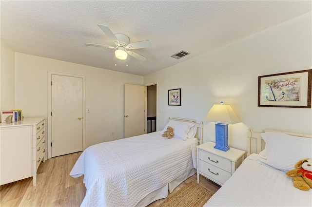 6840 Midnight Pass Rd Unit 6840, Sarasota, FL 34242 - bedroom featuring light wood finished floors, a ceiling fan, and a textured ceiling