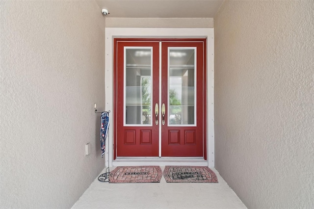 5802 Alabaster Stone Ln, Apollo Beach, FL 33572 - property entrance with french doors, stucco siding, and a security system