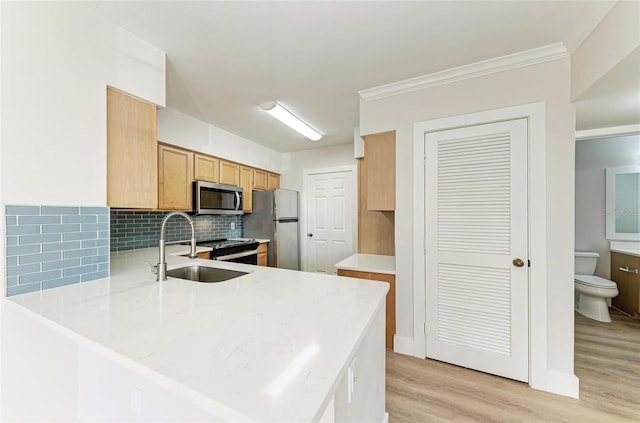 3005 Chianti Ct Unit 103, Sarasota, FL 34237 - kitchen featuring appliances with stainless steel finishes, light wood-type flooring, decorative backsplash, a peninsula, and crown molding