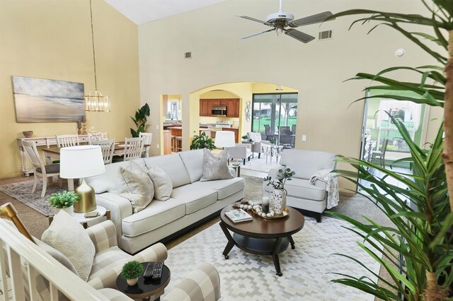 175 Inlets Blvd Unit 175, Nokomis, FL 34275 - living room with arched walkways, a high ceiling, a ceiling fan, and a chandelier