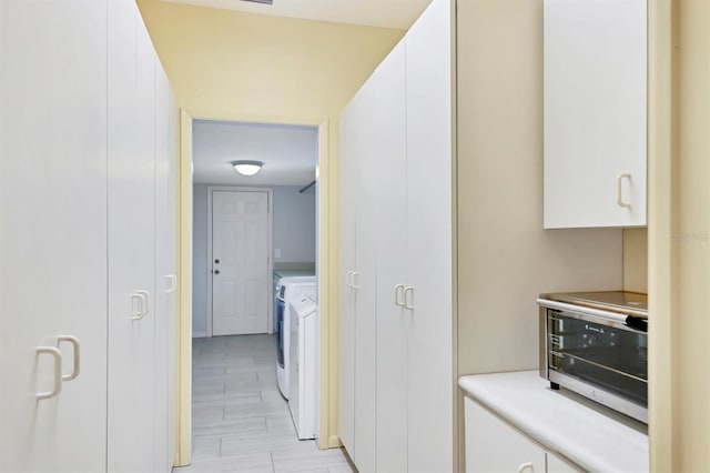 175 Inlets Blvd Unit 175, Nokomis, FL 34275 - kitchen featuring washing machine and dryer, white cabinetry, and light countertops