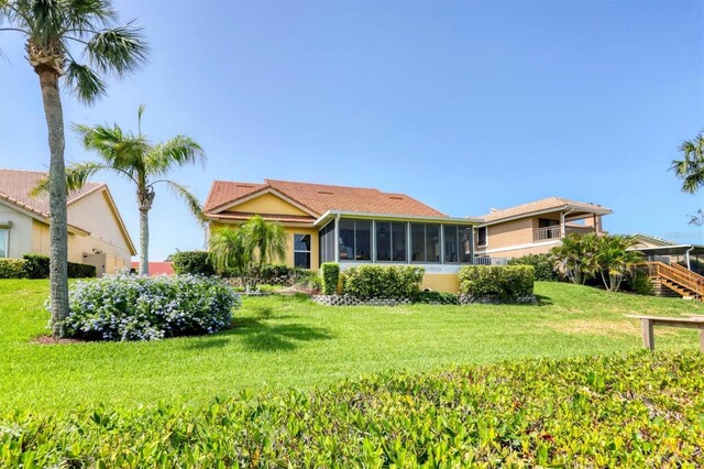 175 Inlets Blvd Unit 175, Nokomis, FL 34275 - rear view of property with stucco siding, a sunroom, and a lawn