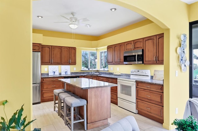 175 Inlets Blvd Unit 175, Nokomis, FL 34275 - kitchen featuring stainless steel appliances, a kitchen bar, a center island, arched walkways, and ceiling fan
