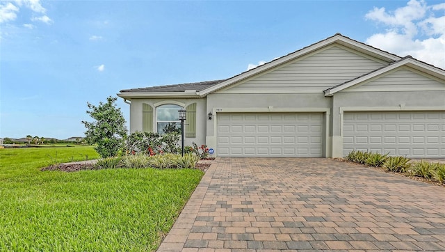 17817 Pastureland Ave, Lakewood Ranch, FL 34211 - single story home with a front yard, decorative driveway, an attached garage, and stucco siding