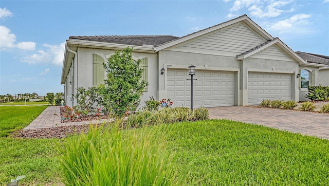 17817 Pastureland Ave, Lakewood Ranch, FL 34211 - view of front of home featuring an attached garage, stucco siding, a front lawn, and driveway