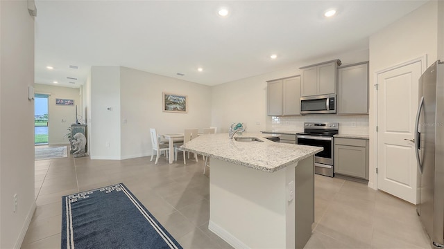 17817 Pastureland Ave, Lakewood Ranch, FL 34211 - kitchen with stainless steel appliances, gray cabinetry, decorative backsplash, a center island with sink, and recessed lighting