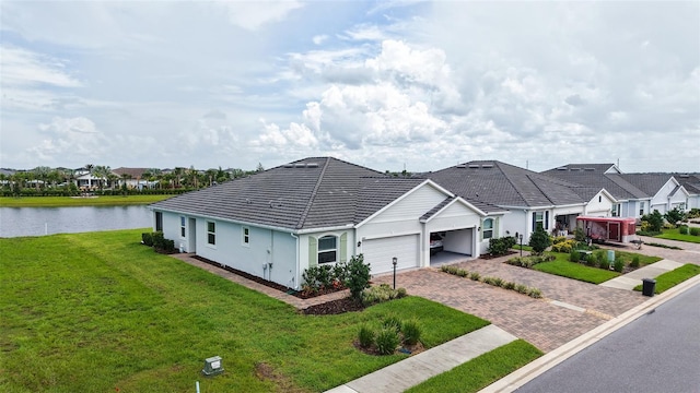 17817 Pastureland Ave, Lakewood Ranch, FL 34211 - view of front facade featuring an attached garage, a water view, decorative driveway, a front yard, and stucco siding