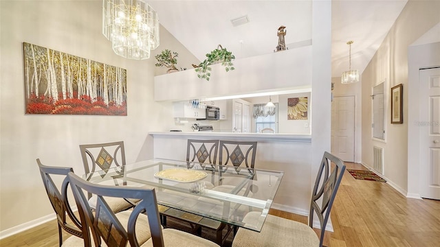 4211 Caddie Dr E Unit 202, Bradenton, FL 34203 - dining space featuring high vaulted ceiling, wood finished floors, and a chandelier