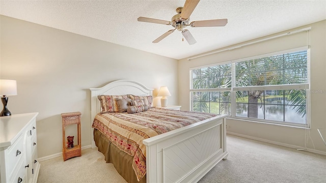 4211 Caddie Dr E Unit 202, Bradenton, FL 34203 - bedroom featuring light carpet, a textured ceiling, and a ceiling fan