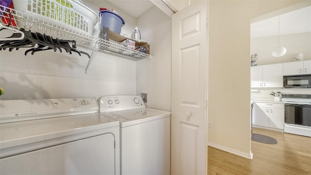 4211 Caddie Dr E Unit 202, Bradenton, FL 34203 - washroom featuring washing machine and dryer and light wood-type flooring