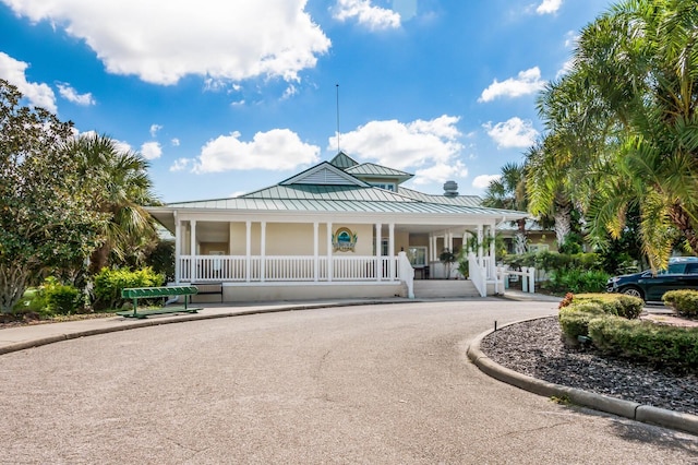 7419 Birds Eye Ter, Bradenton, FL 34203 - view of front of house featuring a standing seam roof, covered porch, a metal roof, and stucco siding