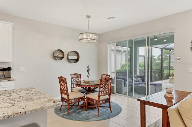 12564 Night View Dr, Sarasota, FL 34238 - dining space with light tile patterned flooring and a chandelier