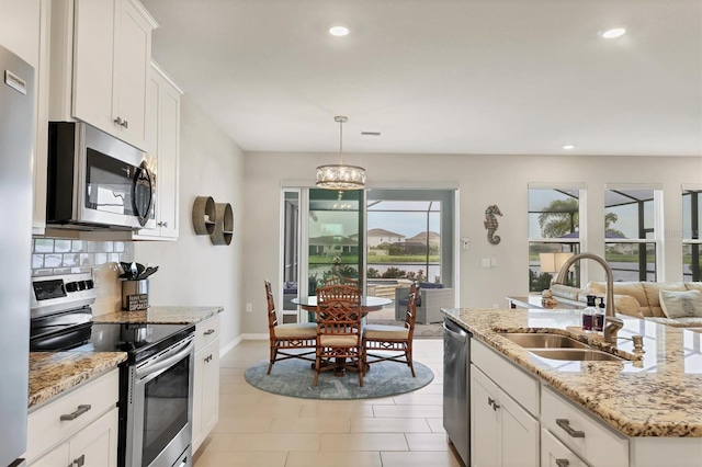 12564 Night View Dr, Sarasota, FL 34238 - kitchen with appliances with stainless steel finishes, backsplash, recessed lighting, white cabinetry, and pendant lighting