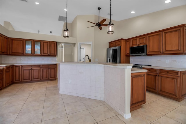 2148 Date Palm Way, Venice, FL 34292 - kitchen featuring stainless steel appliances, a ceiling fan, brown cabinetry, light countertops, and decorative backsplash