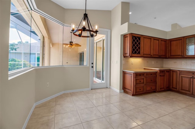 2148 Date Palm Way, Venice, FL 34292 - kitchen featuring a chandelier, light countertops, brown cabinetry, light tile patterned floors, and backsplash
