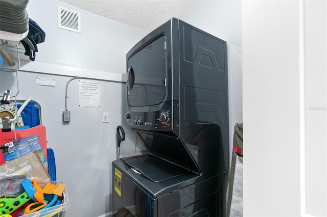 6312 Midnight Pass Rd Unit 102S, Sarasota, FL 34242 - washroom with estacked washer and dryer and a textured ceiling