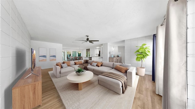 4455 Emerald Ridge Dr, Sarasota, FL 34233 - living area featuring light wood-type flooring, ceiling fan, and tile walls