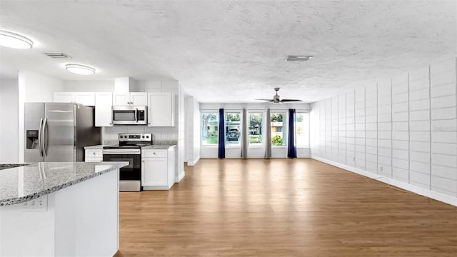 4455 Emerald Ridge Dr, Sarasota, FL 34233 - kitchen featuring stainless steel appliances, light wood finished floors, white cabinetry, light stone counters, and ceiling fan