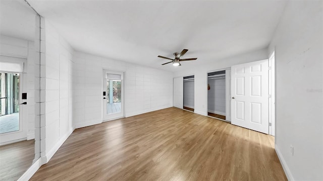 4455 Emerald Ridge Dr, Sarasota, FL 34233 - unfurnished bedroom featuring wood finished floors, multiple windows, and two closets