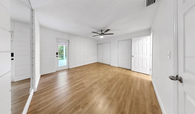 4455 Emerald Ridge Dr, Sarasota, FL 34233 - unfurnished bedroom with wood finished floors, two closets, and ceiling fan