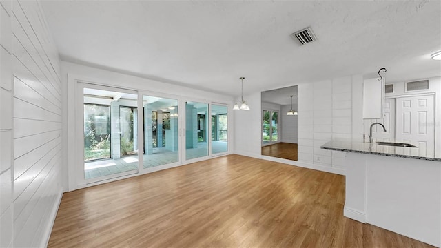4455 Emerald Ridge Dr, Sarasota, FL 34233 - unfurnished living room featuring a sink and light wood-style floors