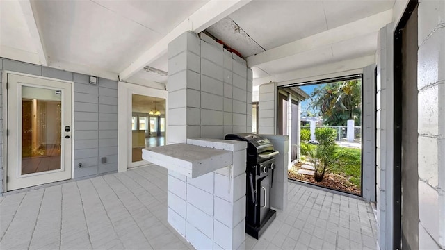 4455 Emerald Ridge Dr, Sarasota, FL 34233 - kitchen with light tile patterned flooring, tile walls, and beam ceiling