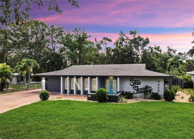 4455 Emerald Ridge Dr, Sarasota, FL 34233 - ranch-style home with a garage, a front lawn, driveway, and roof with shingles