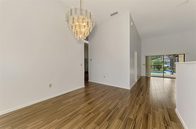 1144 Hoover St, Nokomis, FL 34275 - unfurnished room featuring a chandelier, high vaulted ceiling, and wood finished floors