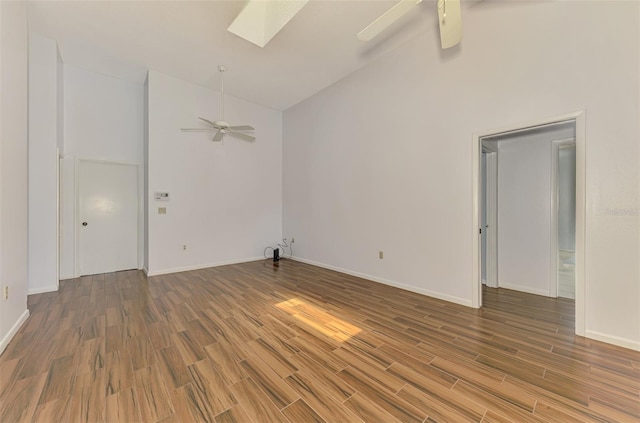 1144 Hoover St, Nokomis, FL 34275 - unfurnished room with ceiling fan, wood finished floors, high vaulted ceiling, and a skylight