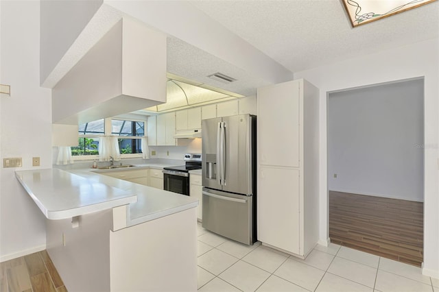 1144 Hoover St, Nokomis, FL 34275 - kitchen with stainless steel appliances, a peninsula, under cabinet range hood, light countertops, and a textured ceiling