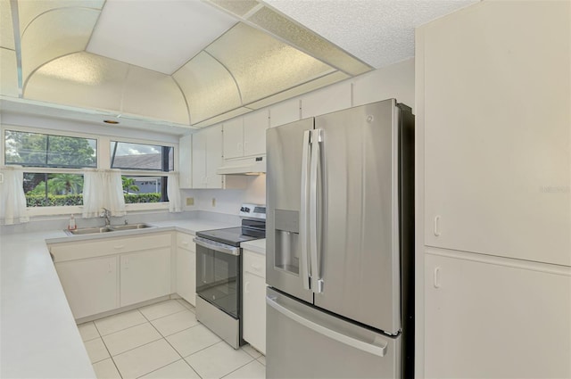 1144 Hoover St, Nokomis, FL 34275 - kitchen featuring appliances with stainless steel finishes, under cabinet range hood, light tile patterned floors, light countertops, and white cabinets