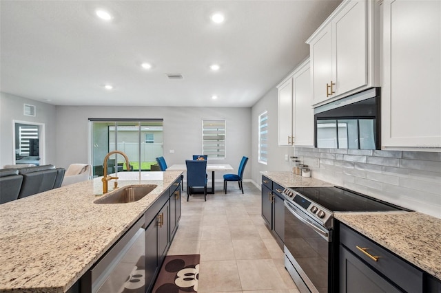4405 Weathered Moss Gln, Palmetto, FL 34221 - kitchen with stainless steel appliances, recessed lighting, white cabinetry, decorative backsplash, and light stone counters