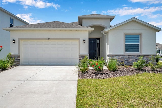 4405 Weathered Moss Gln, Palmetto, FL 34221 - view of front of house featuring stone siding, stucco siding, a garage, and driveway