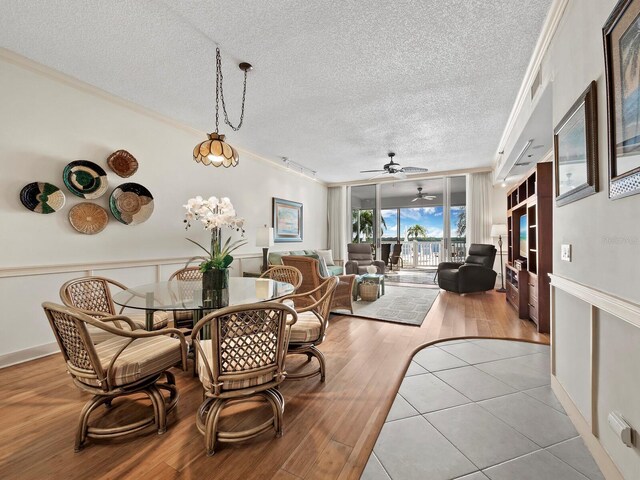 615 Dream Island Pl Unit 105, Longboat Key, FL 34228 - dining space with ornamental molding, a textured ceiling, ceiling fan, and wood finished floors