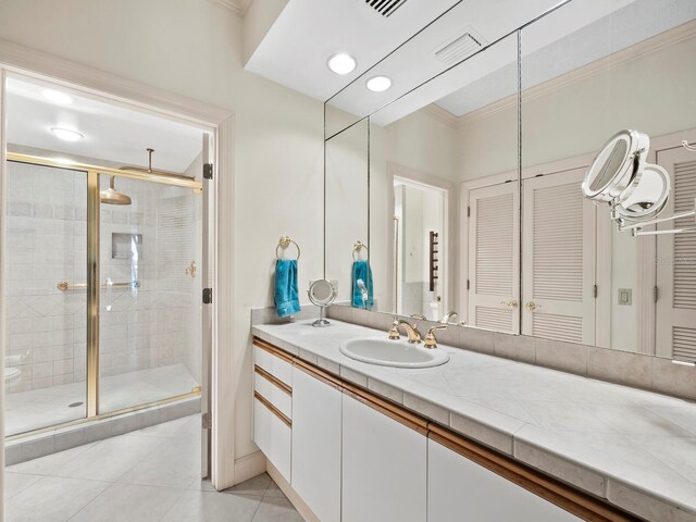 615 Dream Island Pl Unit 105, Longboat Key, FL 34228 - bathroom with tile patterned floors, a shower stall, vanity, crown molding, and a closet