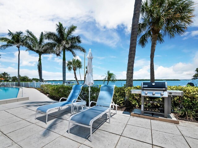 615 Dream Island Pl Unit 105, Longboat Key, FL 34228 - view of patio / terrace featuring a grill, a community pool, and a water view