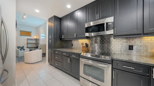 1921 Monte Carlo Dr Unit 302, Sarasota, FL 34231 - kitchen featuring appliances with stainless steel finishes, stone counters, tasteful backsplash, light tile patterned floors, and recessed lighting