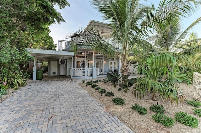 160 Coolidge Dr, Sarasota, FL 34236 - view of front of house featuring covered porch, a carport, driveway, stucco siding, and a balcony
