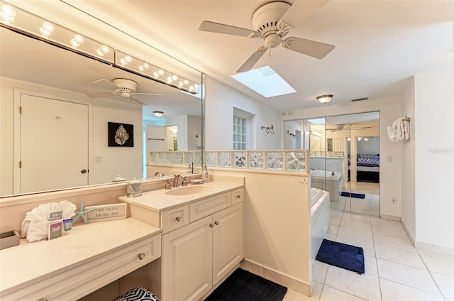 160 Coolidge Dr, Sarasota, FL 34236 - ensuite bathroom with ceiling fan, a skylight, tile patterned floors, and a garden tub