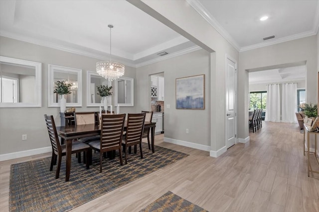 3344 Anchor Bay Trl, Bradenton, FL 34211 - dining area with light wood-style flooring, a chandelier, ornamental molding, and a raised ceiling
