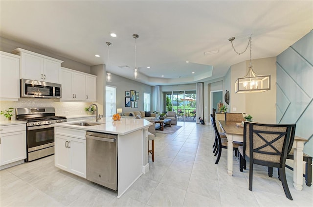 11685 Great Brook Ln, Parrish, FL 34219 - kitchen with stainless steel appliances, open floor plan, hanging light fixtures, light countertops, and backsplash