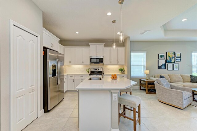 11685 Great Brook Ln, Parrish, FL 34219 - kitchen with appliances with stainless steel finishes, light tile patterned floors, open floor plan, a kitchen breakfast bar, and tasteful backsplash