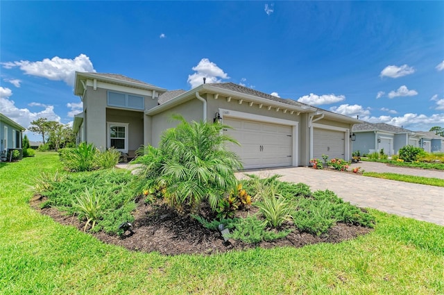 11685 Great Brook Ln, Parrish, FL 34219 - view of front of home featuring stucco siding, a garage, driveway, and a front yard