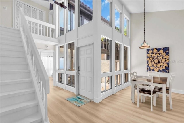 800 S Blvd Of The Presidents Unit 16, Sarasota, FL 34236 - dining area with a towering ceiling, light wood finished floors, and stairway