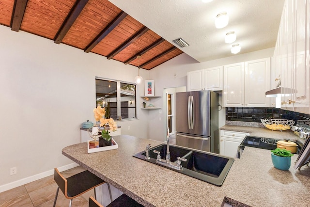 4232 Pandora Rd, Venice, FL 34293 - kitchen featuring freestanding refrigerator, wood ceiling, white cabinetry, a peninsula, and tasteful backsplash