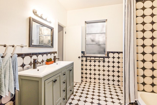 4232 Pandora Rd, Venice, FL 34293 - bathroom with tile walls, double vanity, wainscoting, a tub to relax in, and curtained shower