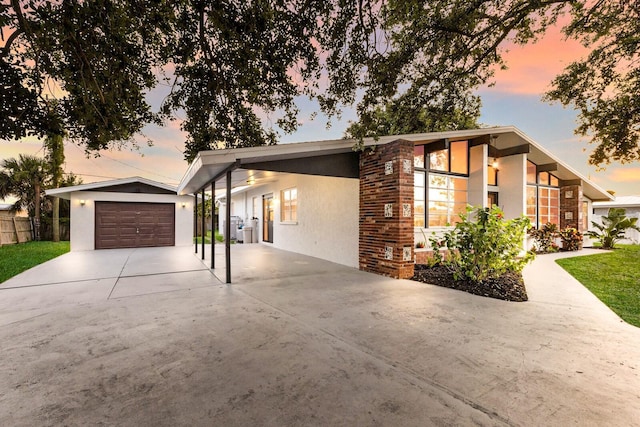 4232 Pandora Rd, Venice, FL 34293 - mid-century home featuring stucco siding, driveway, an outbuilding, and brick siding
