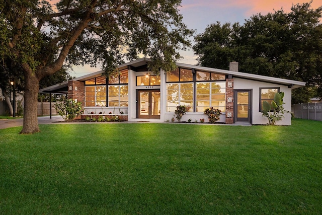 4232 Pandora Rd, Venice, FL 34293 - back of property at dusk with an attached carport, a chimney, and driveway